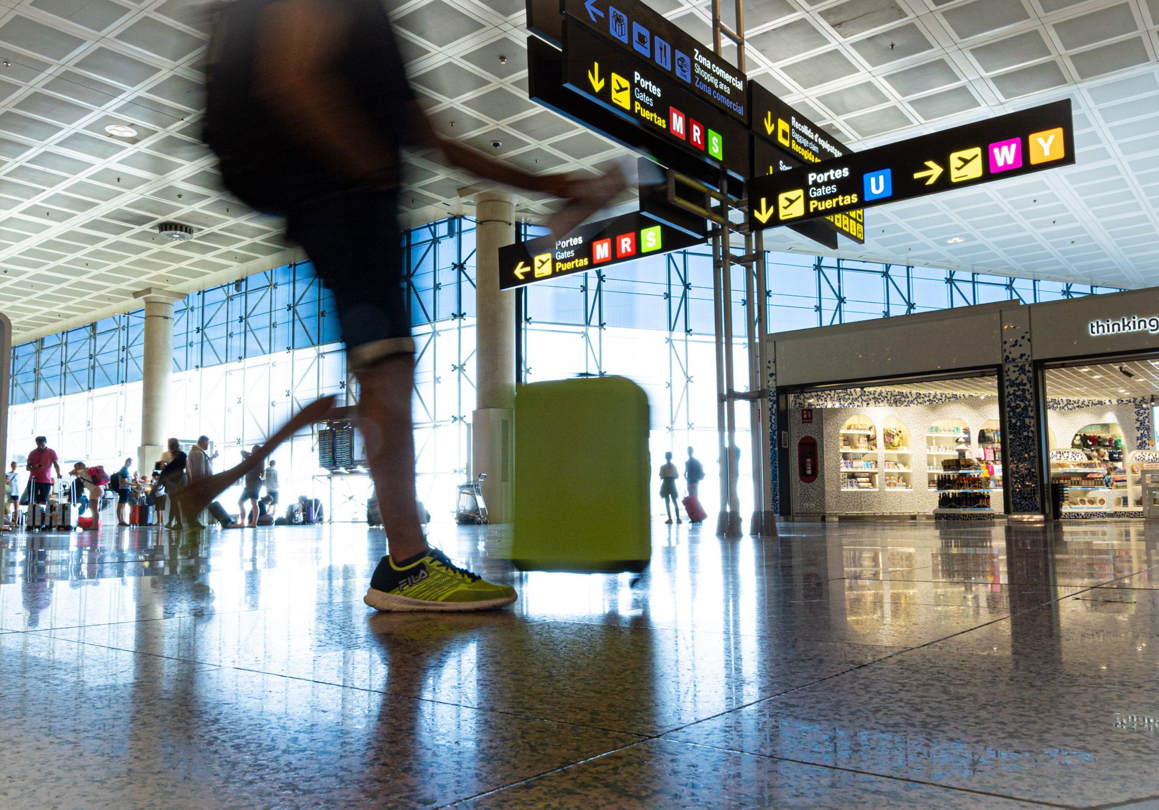 Barcelona, Spain. August 2019: Passengers in transit in Terminal 2 of Barcelona el Prat - Josep Tarradellas international airport with a Dutyfree stores in background.