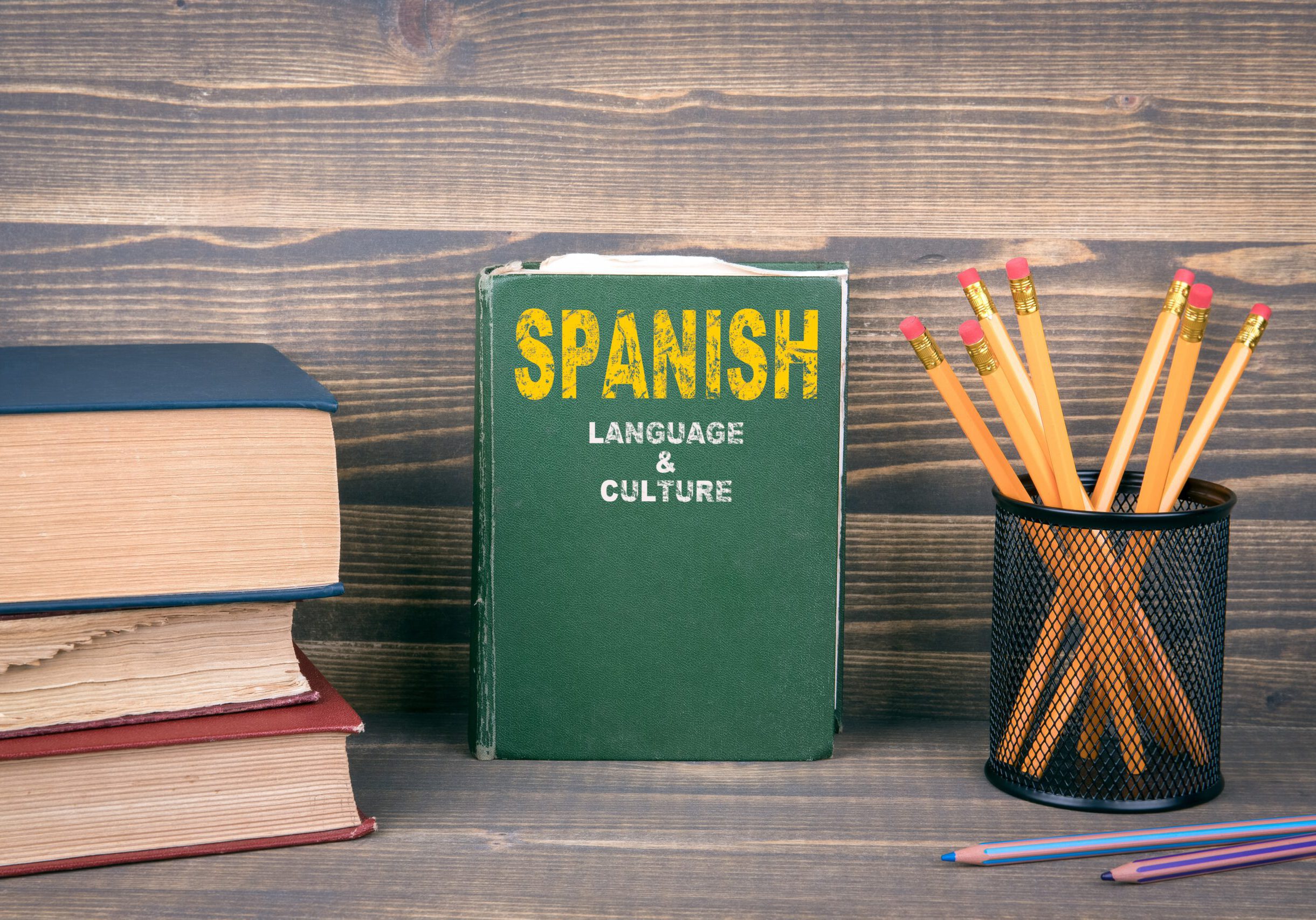 Spanish language and culture concept. Book on a wooden background